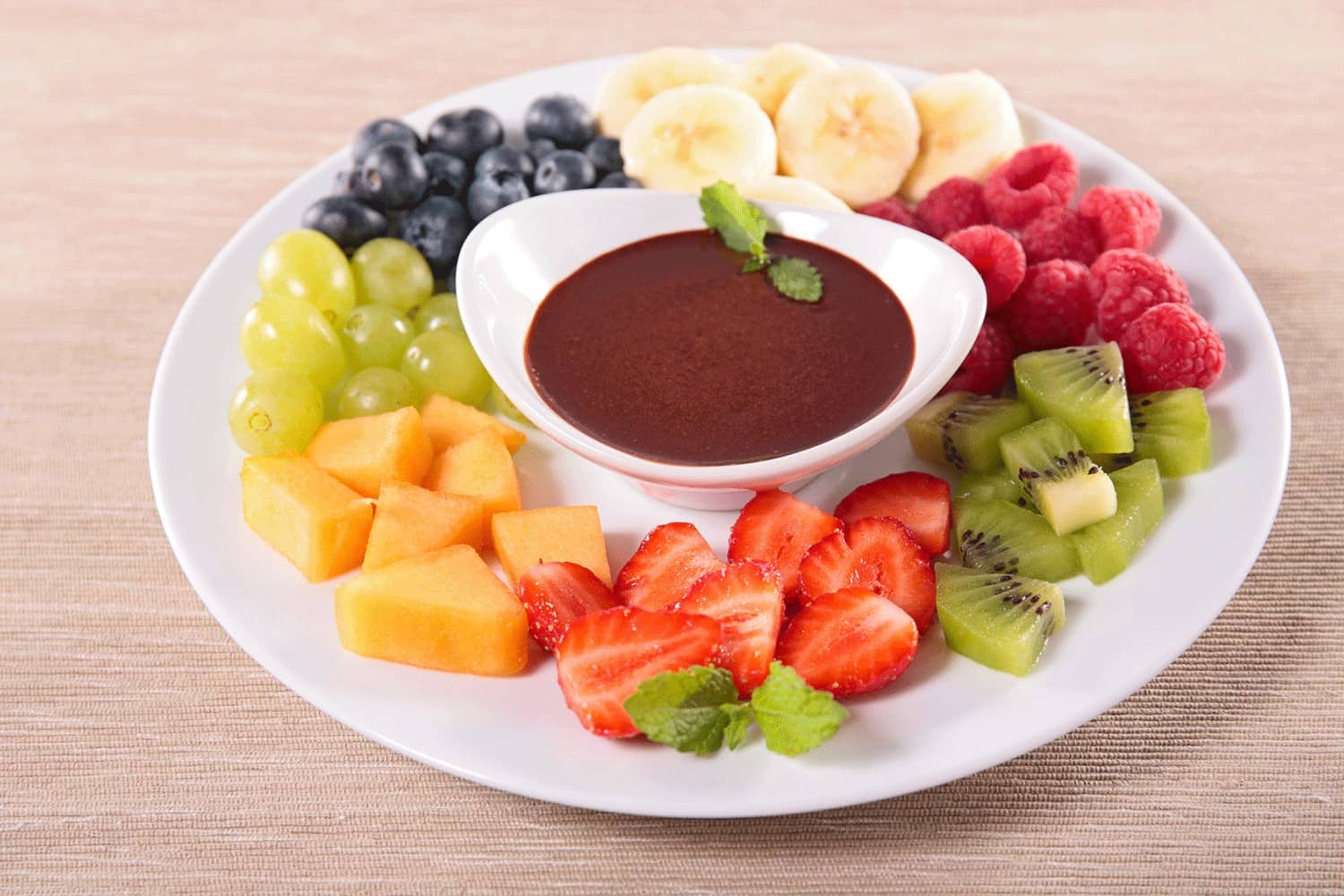 crème de chocolat entouré de fruits coupés